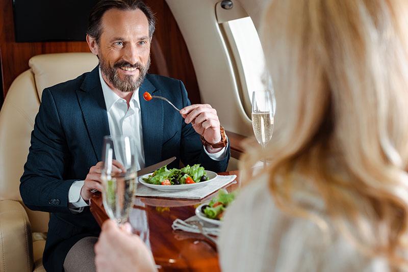 Image of business man with a catered dining experience in a private chartered flight.